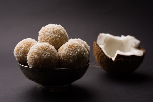 Homemade Coconut Sweet Laddoo LUB Nariyal Laddu z mlekiem skondensowanym i cukrem, popularne jedzenie festiwalowe. Podawane na nastrojowym tle, selektywne skupienie