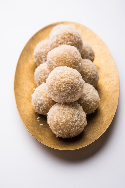 Homemade Coconut Sweet Laddoo LUB Nariyal Laddu z mlekiem skondensowanym i cukrem, popularne jedzenie festiwalowe. Podawane na nastrojowym tle, selektywne skupienie