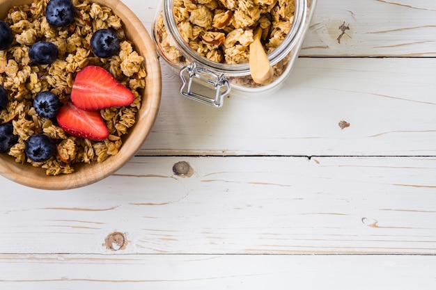 Homemade granola i świeże owoce jagodowe na stół drewna z miejsca.