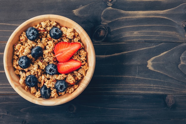 Homemade granola i świeże owoce jagodowe na stół drewna z miejsca.