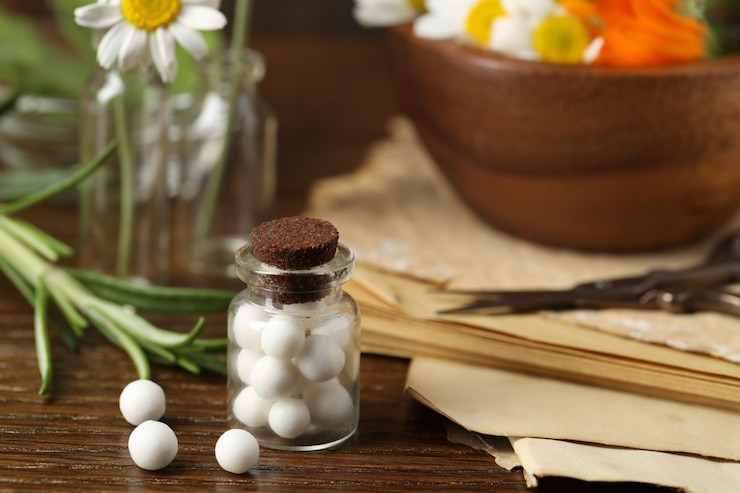 Zdjęcie homeopatia szklana butelka z pigułkami na drewnianym stole
