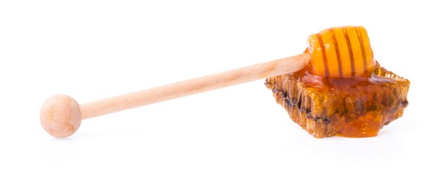 Honeycombs z drewnianą chochlą dla miodu odizolowywającego na białym tle