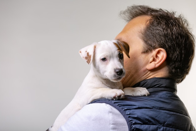 Horyzontalny portret przystojny rozochocony mężczyzna trzyma Jack Russell terrirer