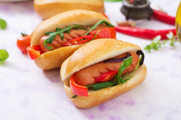 Zdjęcie hot dog z kiełbasą i warzywami w stylu greckim.