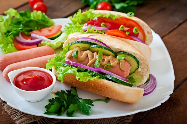 Hotdog Z Keczupem, Musztardą, Sałatą I Warzywami Na Drewnianym Stole