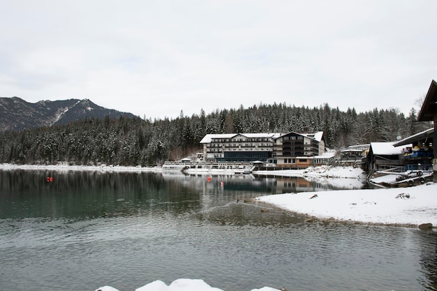 Hotel z zakwaterowaniem nad jeziorem w niemczech zimą w grudniu ze śniegiem i zamarzniętymi drzewami