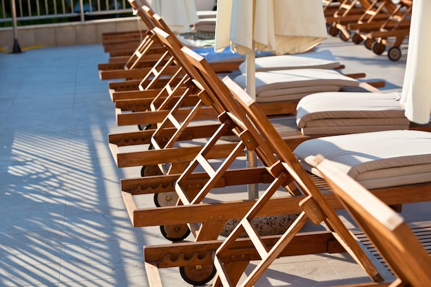 Hotelowe drewniane krzesła przy basenie Poziome ujęcie