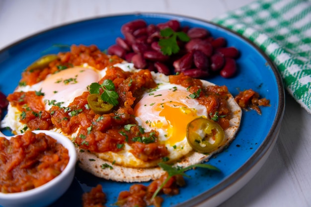 Huevos rancheros to tradycyjne meksykańskie śniadanie, które zasadniczo składa się z jajek sadzonych na kor