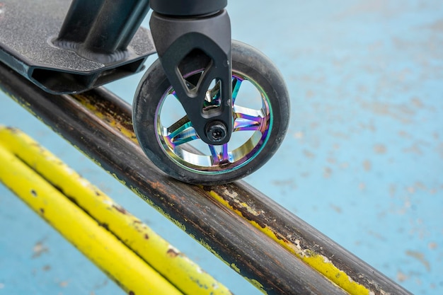 Hulajnoga wyczynowa na żółtej żelaznej rampie skateparku
