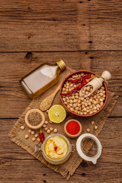 Zdjęcie hummus na starym drewnianym stole. wytrawna ciecierzyca, oliwa z oliwek, cytryna, kminek i papryczka chili