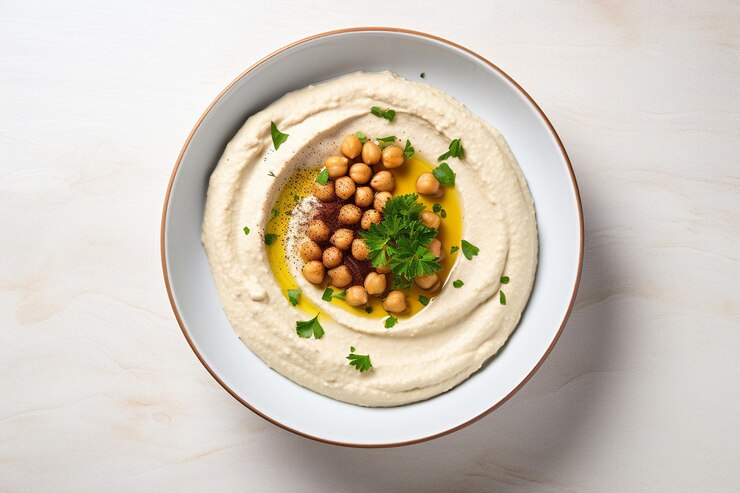 Zdjęcie hummus podawany w kawiarni przy plaży z widokiem na ocean i palmy