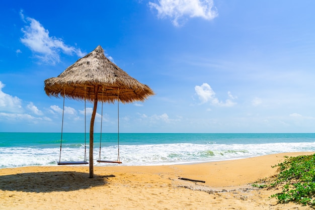 huśtawka na plaży z morzem oceanu i niebieskim tle nieba