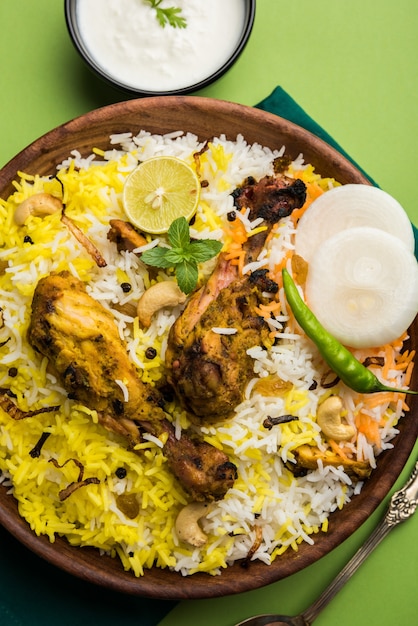 Hyderabadi kurczak lub dum biryani, podawane w kadhai lub misce z dipem jogurtowym. selektywne skupienie