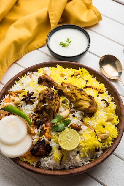 Hyderabadi kurczak lub dum biryani, podawane w kadhai lub misce z dipem jogurtowym. selektywne skupienie