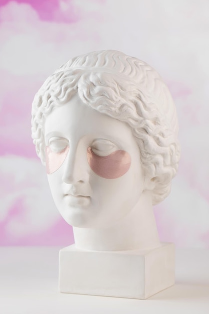 Hydrożelowe różowe plastry na gipsowej głowie Afrodyty na różowym tle Koncepcja piękna
