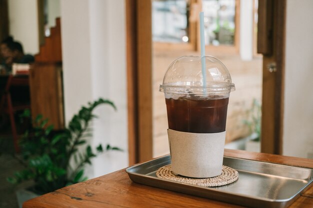 ice coffee americano w filiżance na stół z drewna w kawiarni.