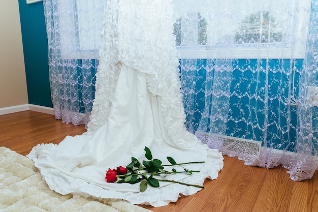 Idealna suknia ślubna z pełną spódnicą w sukience ślubnej pokoju trzymaj czerwoną różę