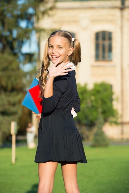 Zdjęcie idealny mundurek szkolny dla dziewcząt trzyma książki edukacja za granicą koncepcja