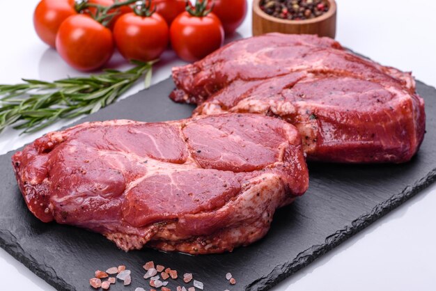 Idealny surowy stek wołowy rib eye na czarnym drewnianym tle, zbliżenie