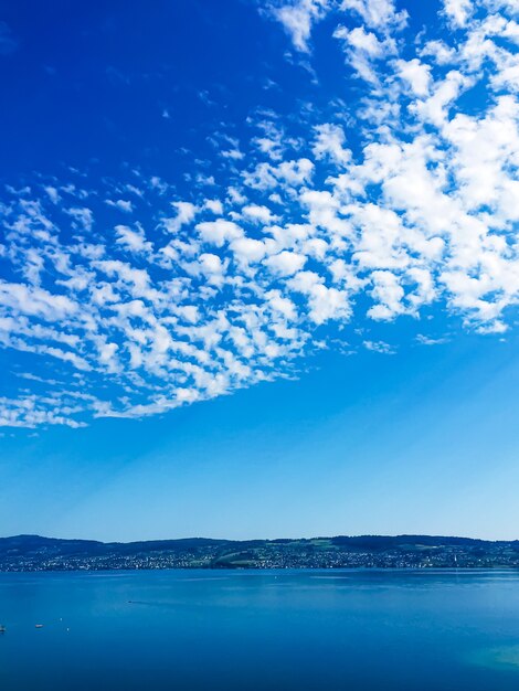 Idylliczny szwajcarski krajobraz widok na jezioro zurych w wollerau kantonie schwyz w szwajcarii góry zurychsee błękitne niebo wody jako letnia przyroda i miejsce podróży idealne jako druk artystyczny