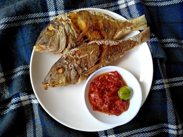 Ikan Goreng czyli smażona ryba na ostro na talerzu Indonezyjska kuchnia kulinarna