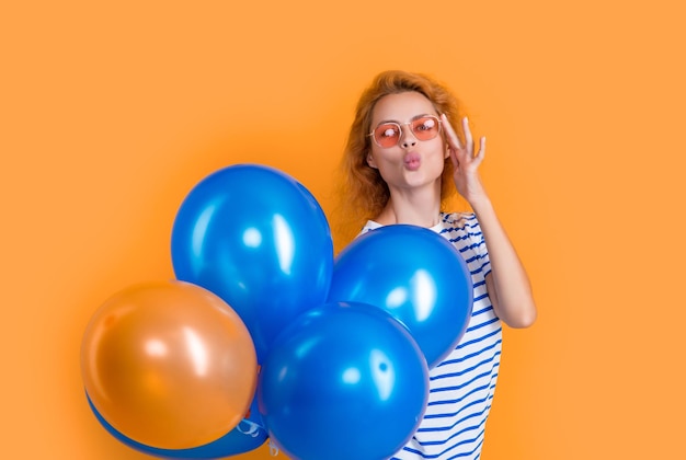 Imprezowa dziewczyna z balonem w okularach przeciwsłonecznych dziewczyna cios pocałunek trzyma balony imprezowe w studio