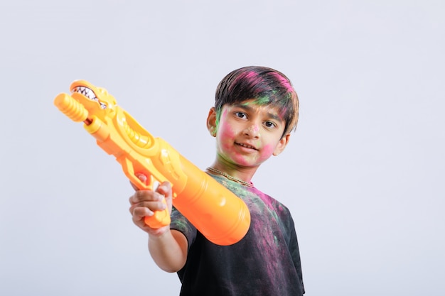 Zdjęcie indian dziecko grając holi z pistoletem koloru