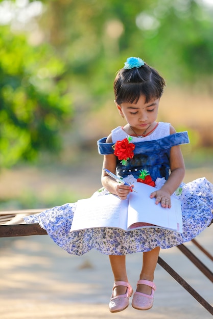 Indian Little Girl dziecko pisze na książki pamiętać, studiuje