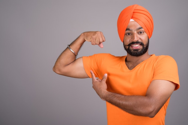 Indian Sikh mężczyzna ubrany w turban i pomarańczową koszulę