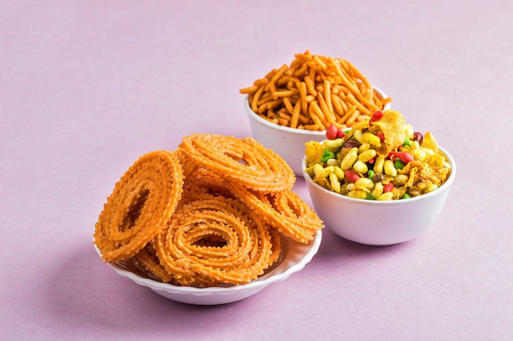 Indian Snack: Chakli, chakali lub Murukku i Besan (mąka Gram) Sev oraz chivada lub chiwada na różowym tle. Diwali Food