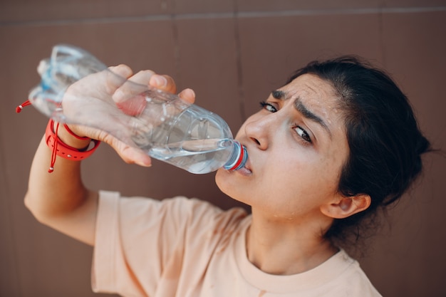 Indianka picie butelkowanej wody niegazowanej ściana zewnętrzna.