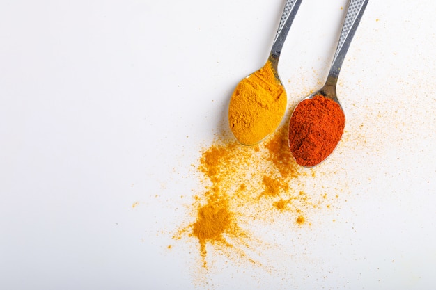 Indiańskie pikantność Chili i turmeric proszek w łyżce na białym tle