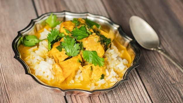 Indiańskiego kurczaka kokosowy curry na drewnianym stole