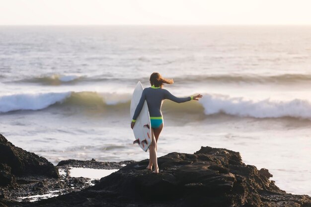 Indonezja, Bali, młoda kobieta z deską surfingową