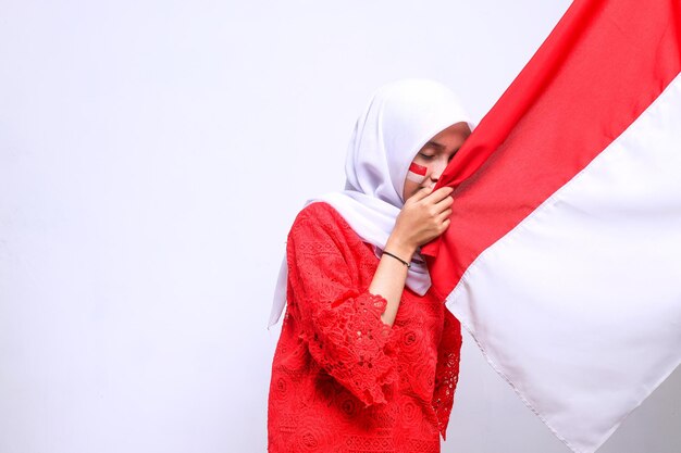 Indonezyjska kobieta świętuje Dzień Niepodległości Indonezji, całując flagę