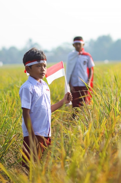 Indonezyjskie Dzieci W Mundurkach Szkolnych Z Flagą Narodową Z Okazji Dnia Niepodległości Indonezji