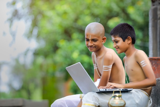 Indyjscy chłopcy uczący się na laptopie