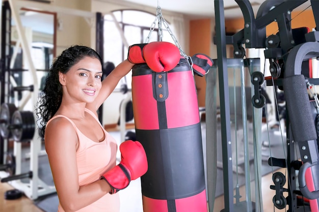Indyjska kobieta opierająca się o worek bokserski