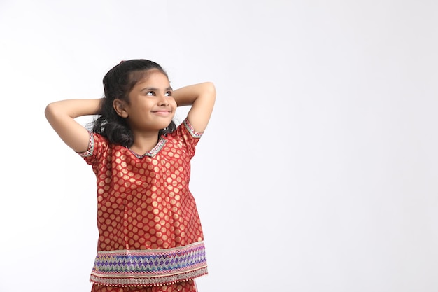 Indyjska mała dziewczynka w tradycyjnym stroju i dająca wyraz na białym tle