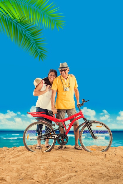 Indyjska para emerytów azjatyckich z rowerem lub rowerem na plaży, nastrojowy efekt