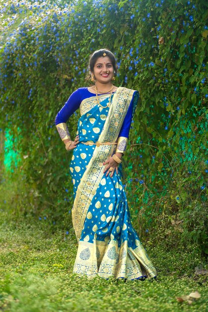 Indyjska tradycyjna piękna młoda dziewczyna w saree pozująca na zewnątrz parku