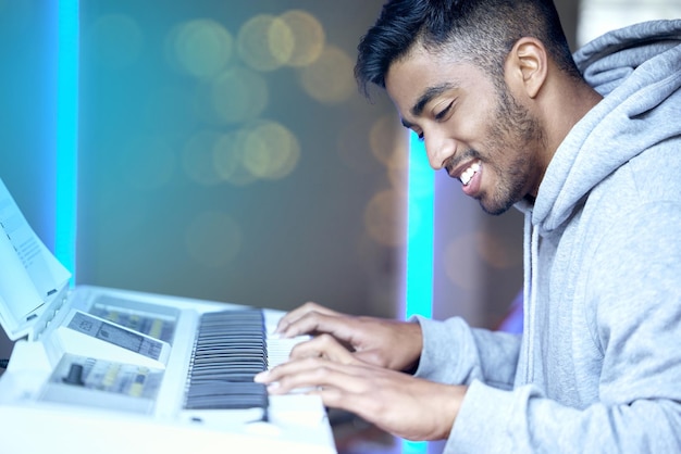 Indyjski człowiek muzyki i szczęśliwy z klawiaturą lub instrumentem do ćwiczenia umiejętności talent i pasja Muzyk próba i uśmiech lub zadowolony z rozwoju kariery fortepian i pewny siebie do wykonania