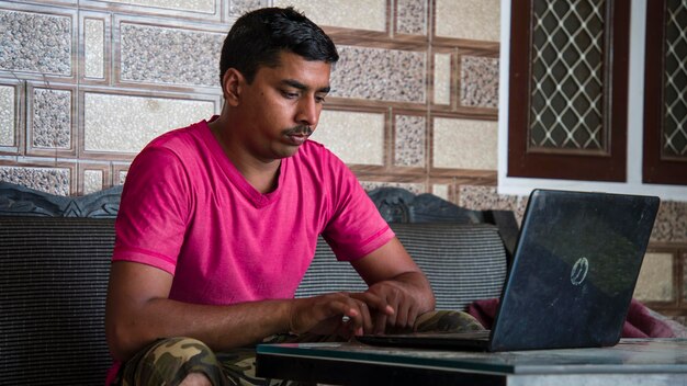 Zdjęcie indyjski facet pracuje z domu na swoim laptopie. praca z domu.