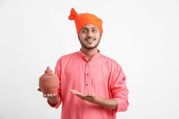 Indyjski mężczyzna trzyma skarbonkę na białej ścianie