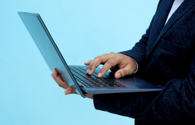Indyjski młody biznesmen w formalnej odzieży za pomocą laptopa