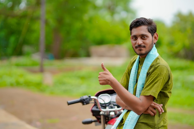 Indyjski rolnik siedzący na rowerze i pokazujący kciuki w górę