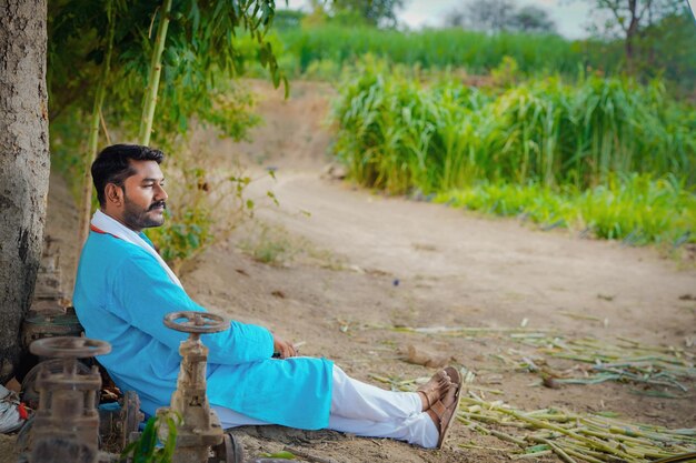 Indyjski rolnik siedzący wygodnie na polu?