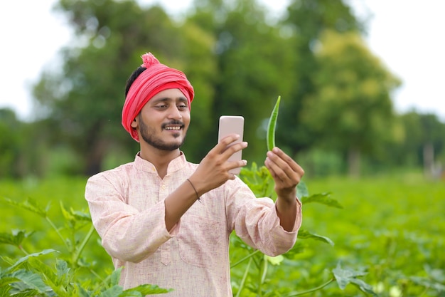 Indyjski rolnik za pomocą smartfona w dziedzinie rolnictwa.