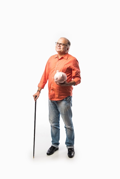 Indyjski staruszek lub emerytowany starszy mężczyzna trzymający skarbonkę lub skarbonkę