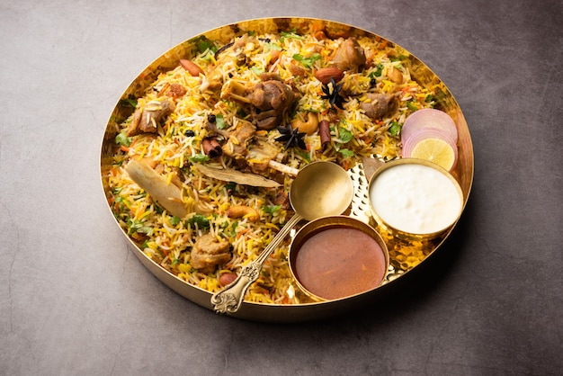 Indyjskie biryani z baraniny przygotowane w ryżu basmati podawane z dipem jogurtowym na nastrojowym tle, selektywne skupienie